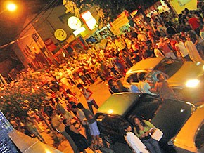 Foto de muitas pessoas no meio da rua à noite