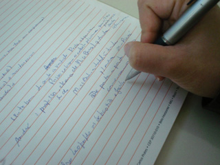 Pessoa escrevendo no caderno