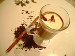 Foto do chocolate quente em uma ta?a com duas pimentas malaguetas secas por cima e canela em pau