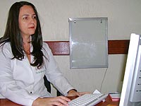 Foto da nutr�loga Carla Val�ria em frente ao computador, digitando