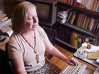 Vanda Arantes 
do Vale em frente ao computador fazendo pesquisas, enquanto d? uma entrevista ao ACESSA.com