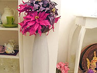 Foto
 de jarra branca grande no canto de uma parede com flores
