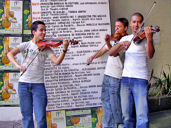 Foto de tr?s alunos do Festival tocando violino