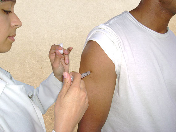 Foto de uma pessoa aplicando vacina
em outra
