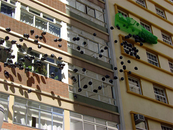 Balões pretos caindo de prédio