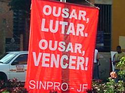 Foto de faixas dos professores manifestando, 
escritas Ousar, Lutar. Ousar, Vencer. Greve