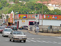 Foto de um carro na sinaliza??o de uma linha f?rrea