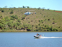 Foto
de um helic?ptero sobre uma das represas e de uma lancha na represa