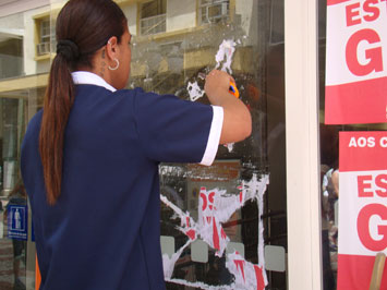 Funcionária remove cartazes de agência bancária na rua Halfeld. Foto: ACESSA.com Banco Itaú
