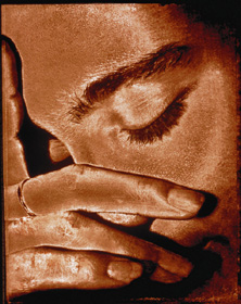 foto ilustrativa de um rosto de uma pessoa 
com olhos fechados, como se estivesse sentindo dor