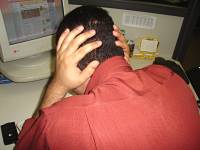 Foto de uma pessoa de costas com as m?os na cabe?a por estar estressada