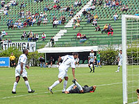 Foto de um jogador ca?do e o outro tentando ajudar