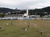 Foto dos jogadores dos dois times em campo, pr?ximo a um dos gols e o ?rbitro de perto