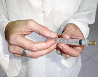 M?dica veterin?ria aplicando uma inje??o de vacina
em um animalzinho