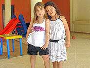 foto de duas meninas uma com vestido e outra com short e blusa