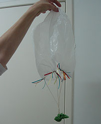 Foto de balão feito com sacola plástica, barbante e pedrinha encapada