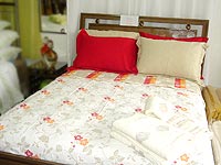 Foto de uma cama arrumada com almofadas e cobre-leito