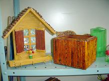 Casinha e caixa feitos com papel de jornal, verniz e tinta. O teto da casa ? feito com pinha.