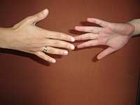 As m?os de duas pessoas tentando encostar uma na outra