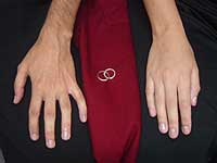 Casal lado a lado que acabaram de tirar as alian?as de casamento