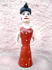 Foto de
uma escultura de mulher de barro em p?, de vestido vermelho e cabelos
amarrados em um coque