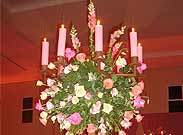 Foto de um arranjo arredondado com rosas e folhas em cima de uma mesa