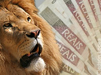Foto de um leão, que representa o IR, e notas de dinheiro