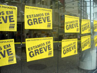 Foto de porta de banco com cartazes indicando greve