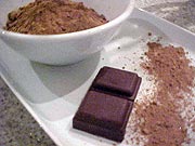 Foto de uma vasilha com chocolate em p?, com barras de chocolate ao lado