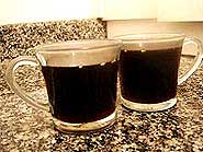 Foto do chocolate quente em uma ta?a e ao lado uma ta?a de licor de creme de cacau