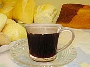 Foto do chocolate quente em uma ta?a e ao lado uma ta?a de licor de creme de cacau em cima de uma mesa decorada