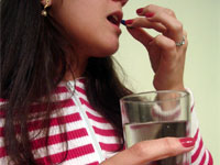 mulher tomando um rem&eacute;dio