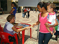 mulher pegando panfleto no mutir&atilde;o