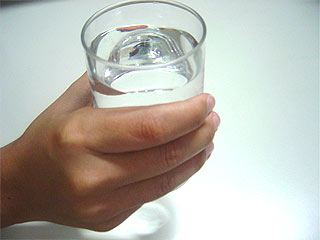 Foto de pessoa segurando copo de agua