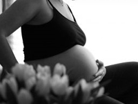 Mulher gr&aacute;vida com a m&atilde;o na barriga