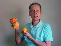 Armando Falconi segurando tomate e mam&atilde;o