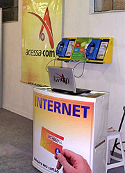 Foto de dois telefones VoIP e um cartaz ao lado da ACESSA.com