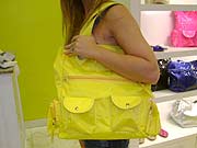 Foto: ACESSA.com Foto de olsa de lona amarela com bolsos no ombro de uma mulher