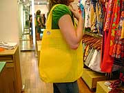 Foto: ACESSA.com Foto de bolsa amarela de plástico no ombro de uma mulher