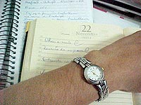 Foto de uma agenda e 
um rel?gio, mostrando a tentativa de administra??o do tempo no trabalho