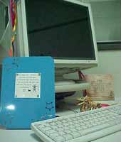 computador com porta retrato e objetos
pessoais por perto